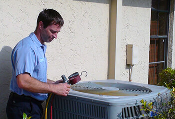 Technician servicing outdoor HVAC unit.